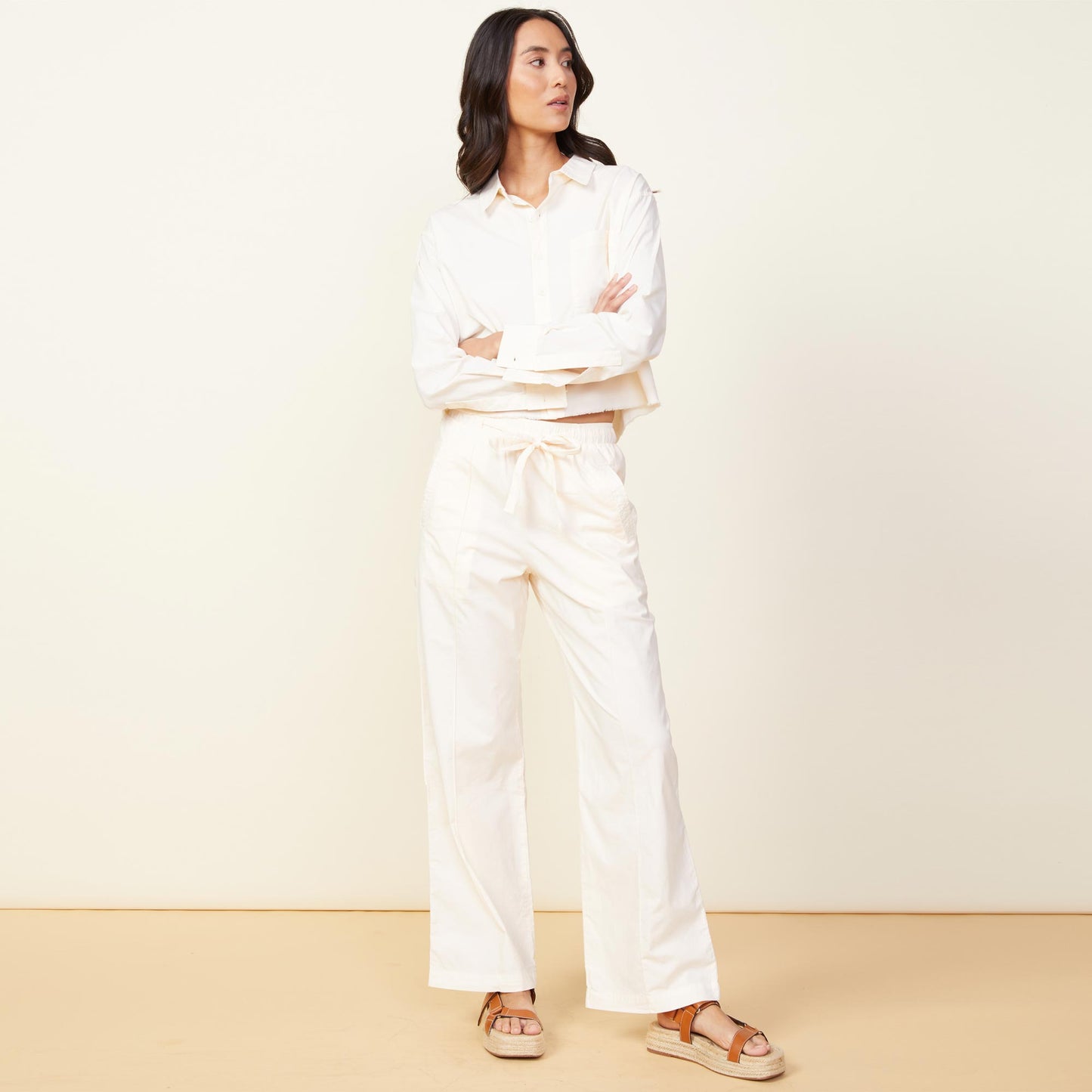 Front view of model wearing the poplin pocket pants in off white.