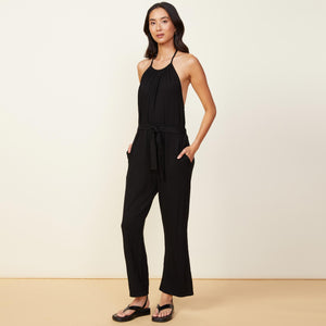Side view of model wearing the supersoft halter jumpsuit in black.