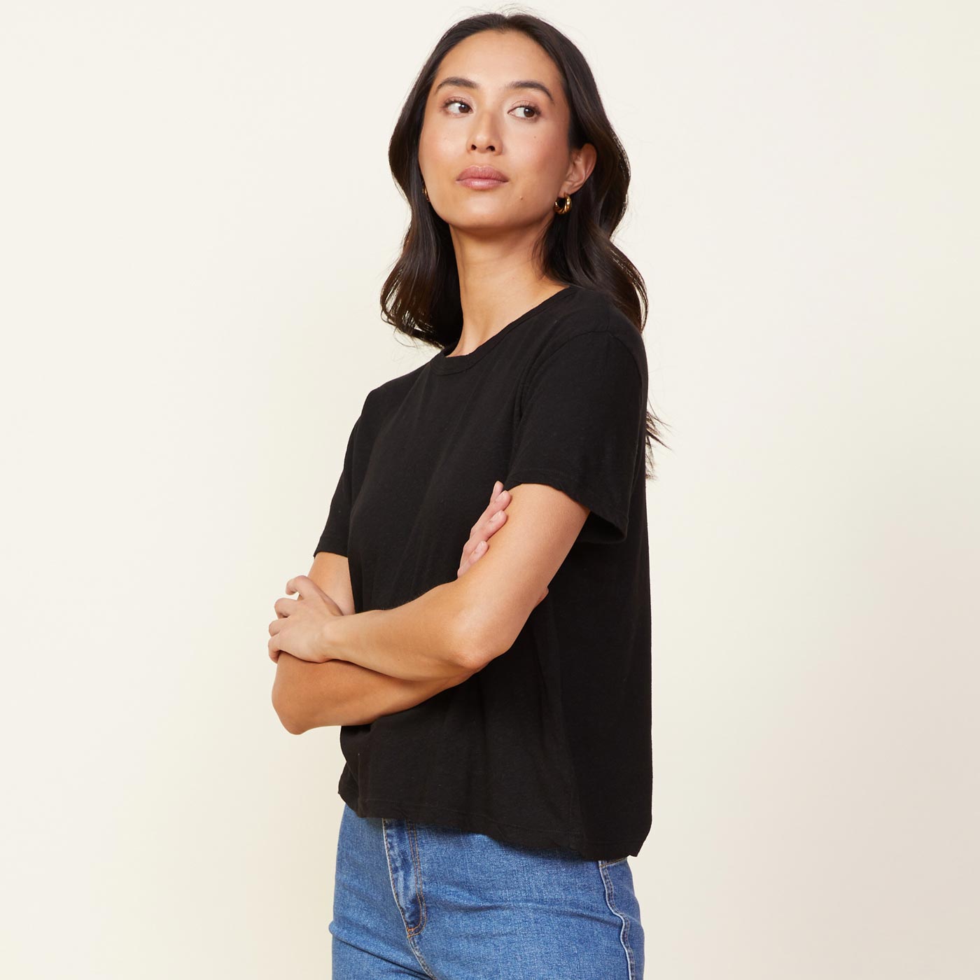 Side view of model wearing the linen athletic tee in black.