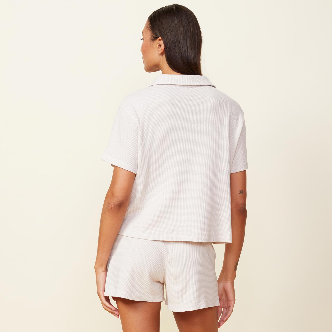 Back view of model wearing the baby thermal vacation shirt in bone.