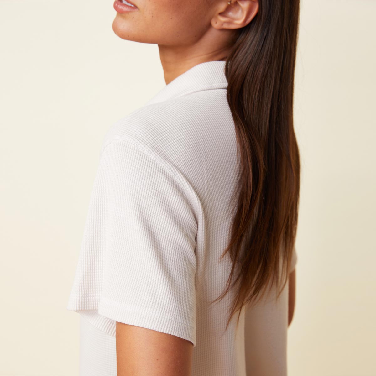 Detail view of model wearing the baby thermal vacation shirt in bone.