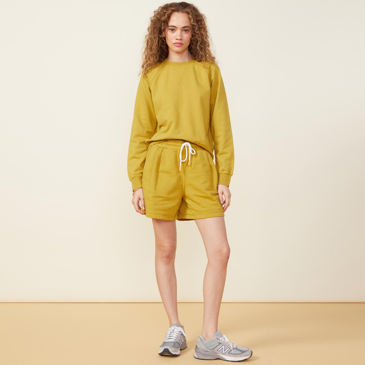 Front view of model wearing the 90's classic sweat short in golden olive.