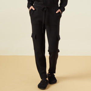 Front view of model wearing the supersoft sweater knit cargo jogger in black.