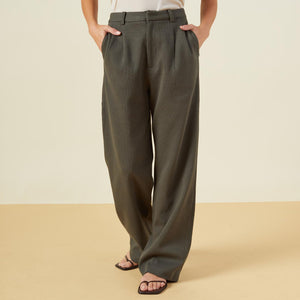 Front view of model wearing the bonded thermal pleated pants in kale green.