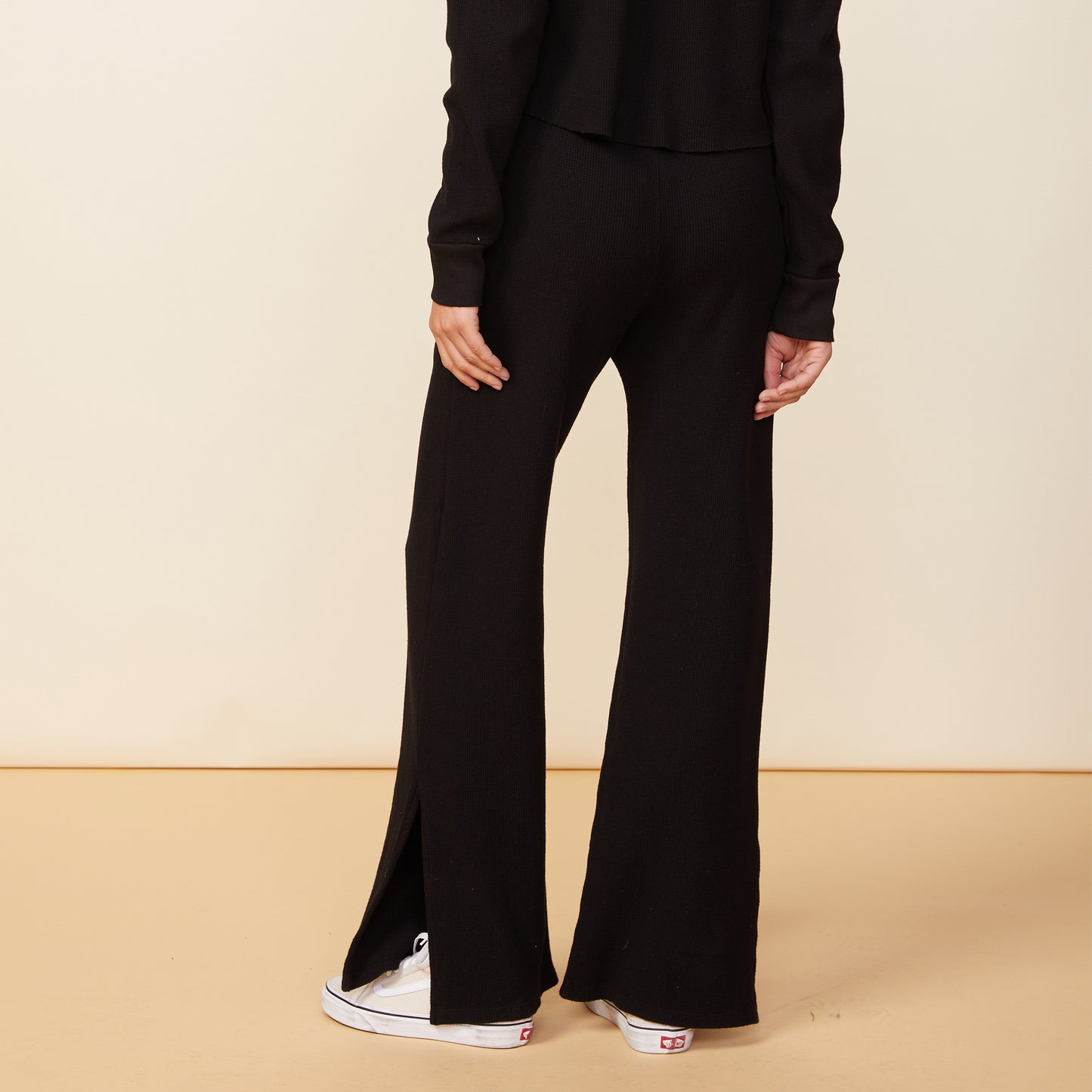 Back view of model wearing the thermal pants in black.