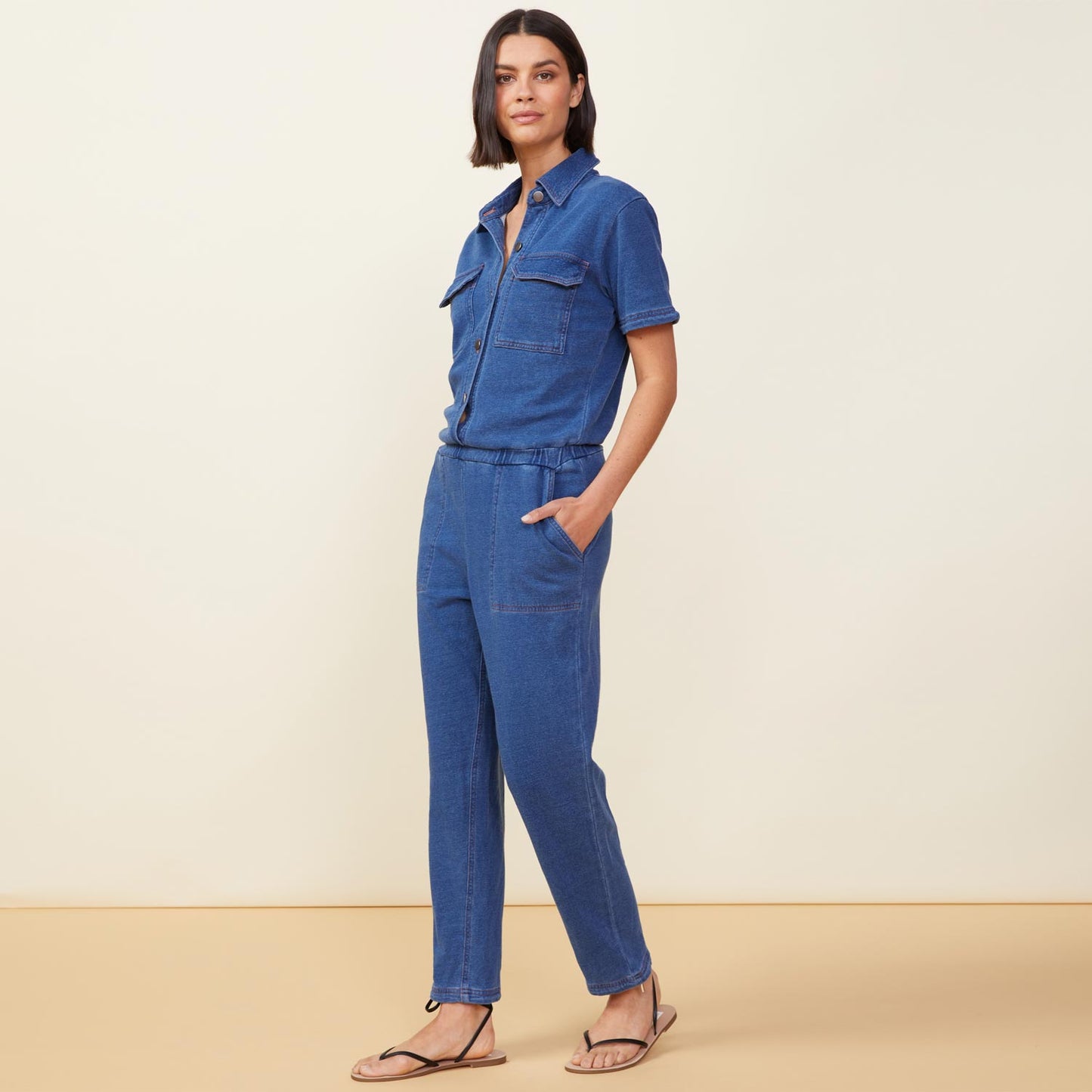 Side view of model wearing the indigo french terry jumpsuit in indigo.