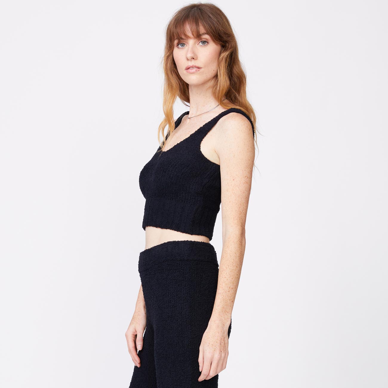 Side view of model wearing the plush sweater tank in black.