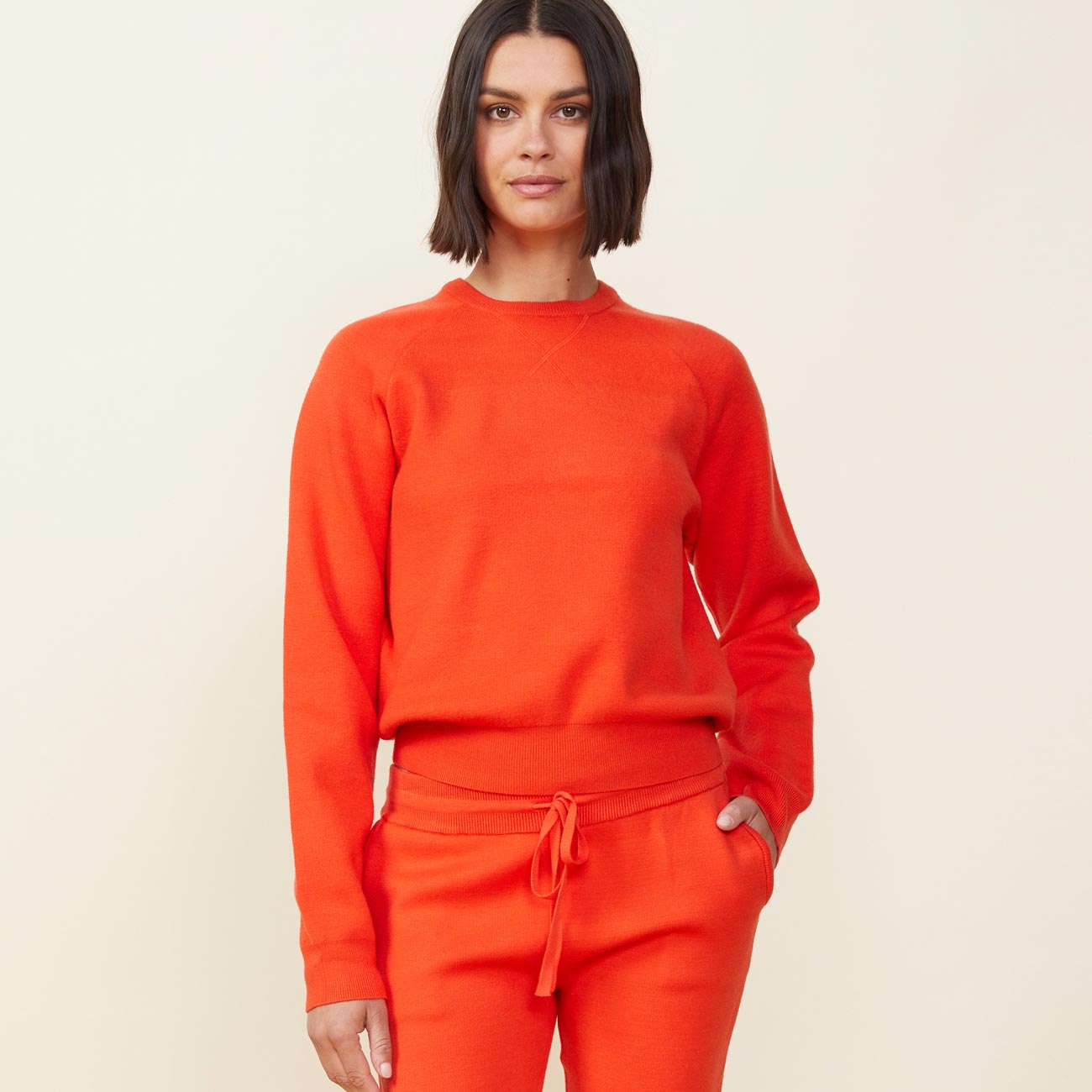 Front view of model wearing the supersoft sweater knit raglan in electric coral.