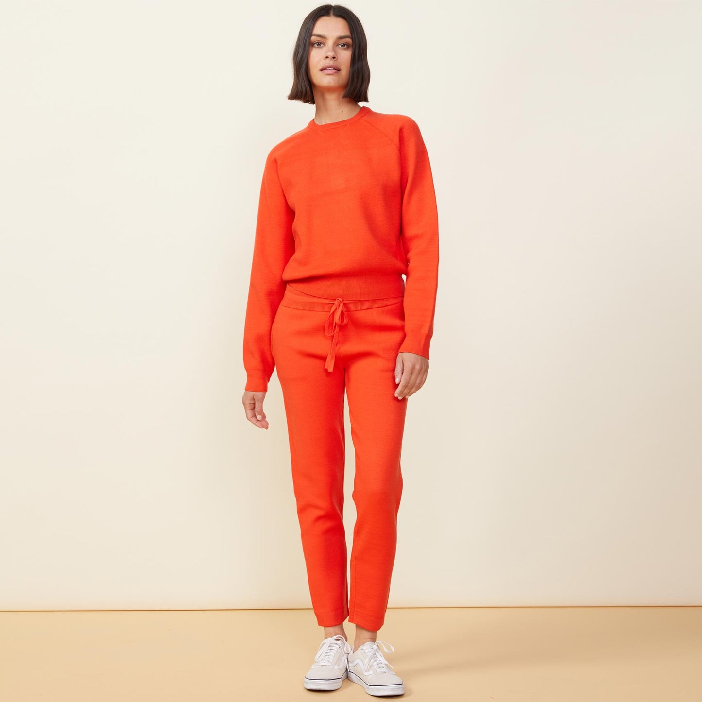 Front view of model wearing the supersoft sweater knit raglan in electric coral.