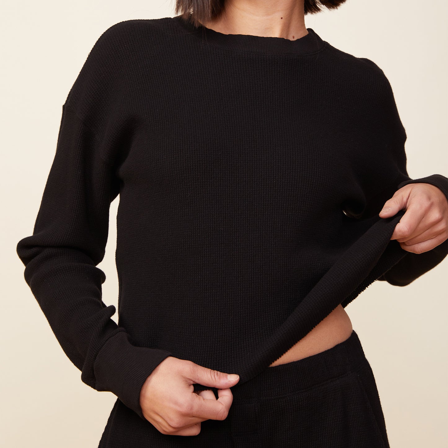 Front view of model wearing the thermal top in black.