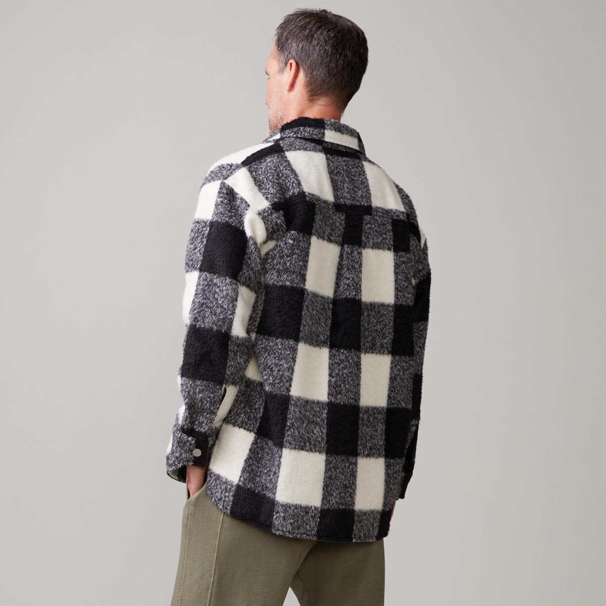 Back view of model wearing the plaid flannel jacket in black, natural check.