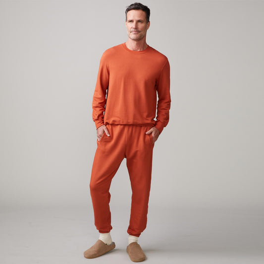 Front view of model wearing the lounge sweatshirt in faded rust.