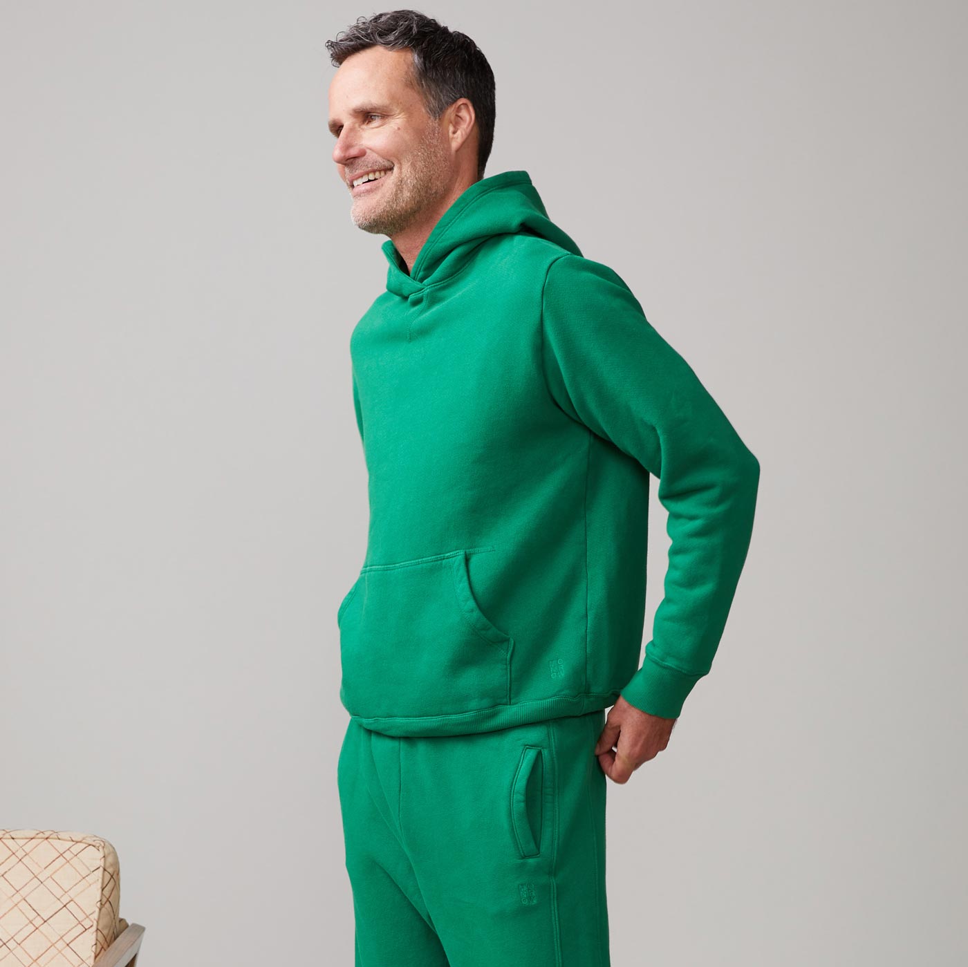 Side view of model wearing the oversized hoody in dusty kelly.