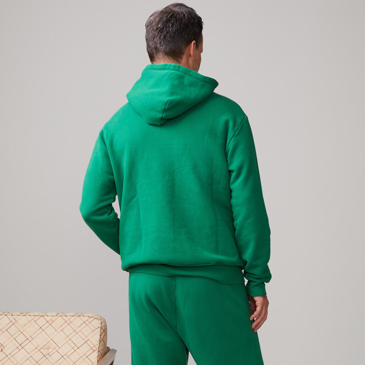 Back view of model wearing the oversized hoody in dusty kelly.