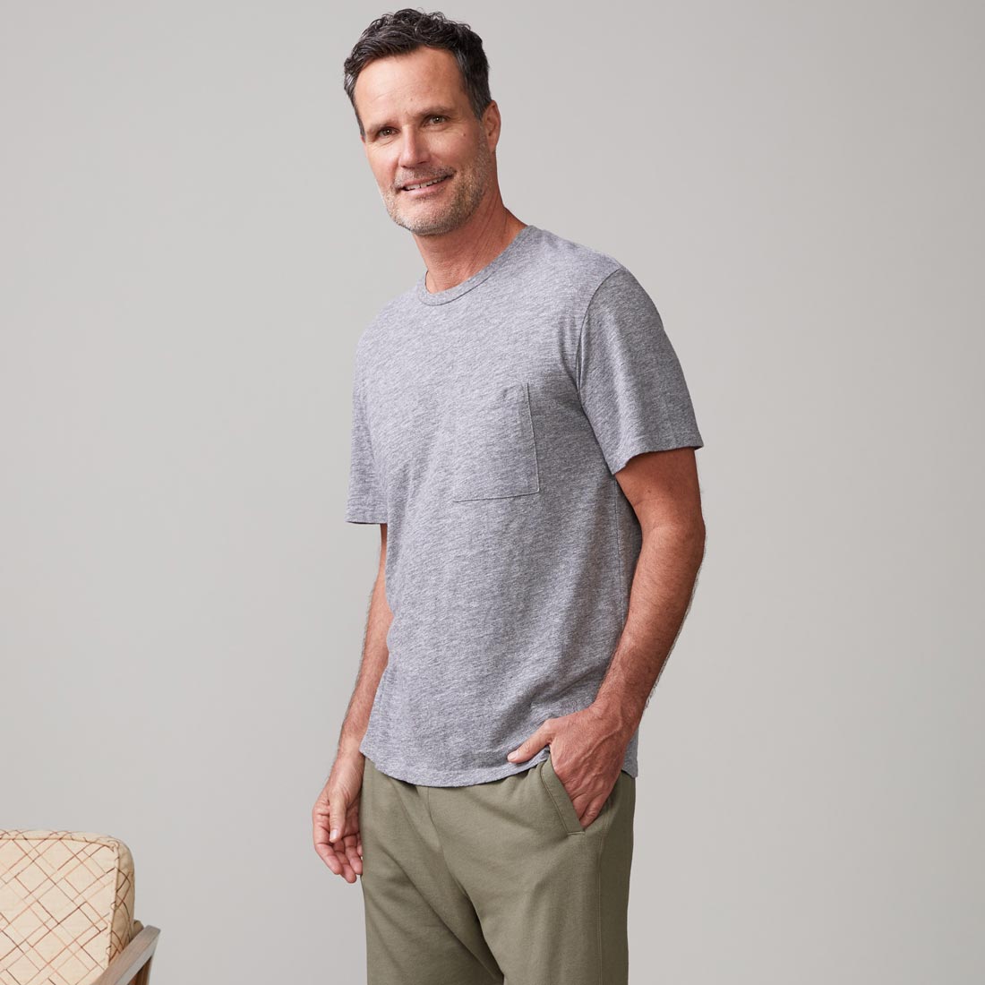 Side view of model wearing the textured tri-blend relaxed pocket crew in granite.