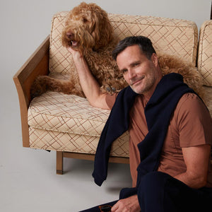 Front view of model wearing the relaxed pocket crew in rust sitting with a dog.