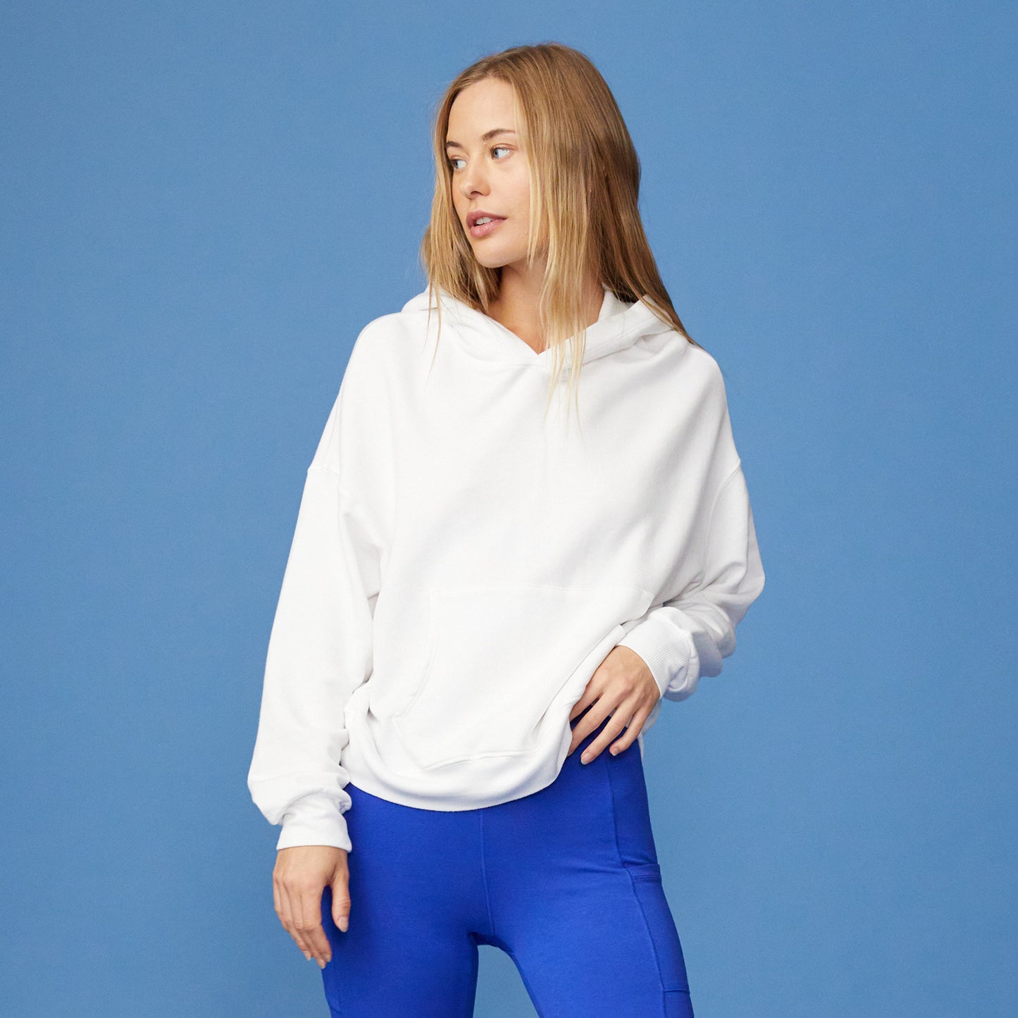 Front view of women in white supersoft fleece slouchy hoody paired with Electric Blue Biker shorts