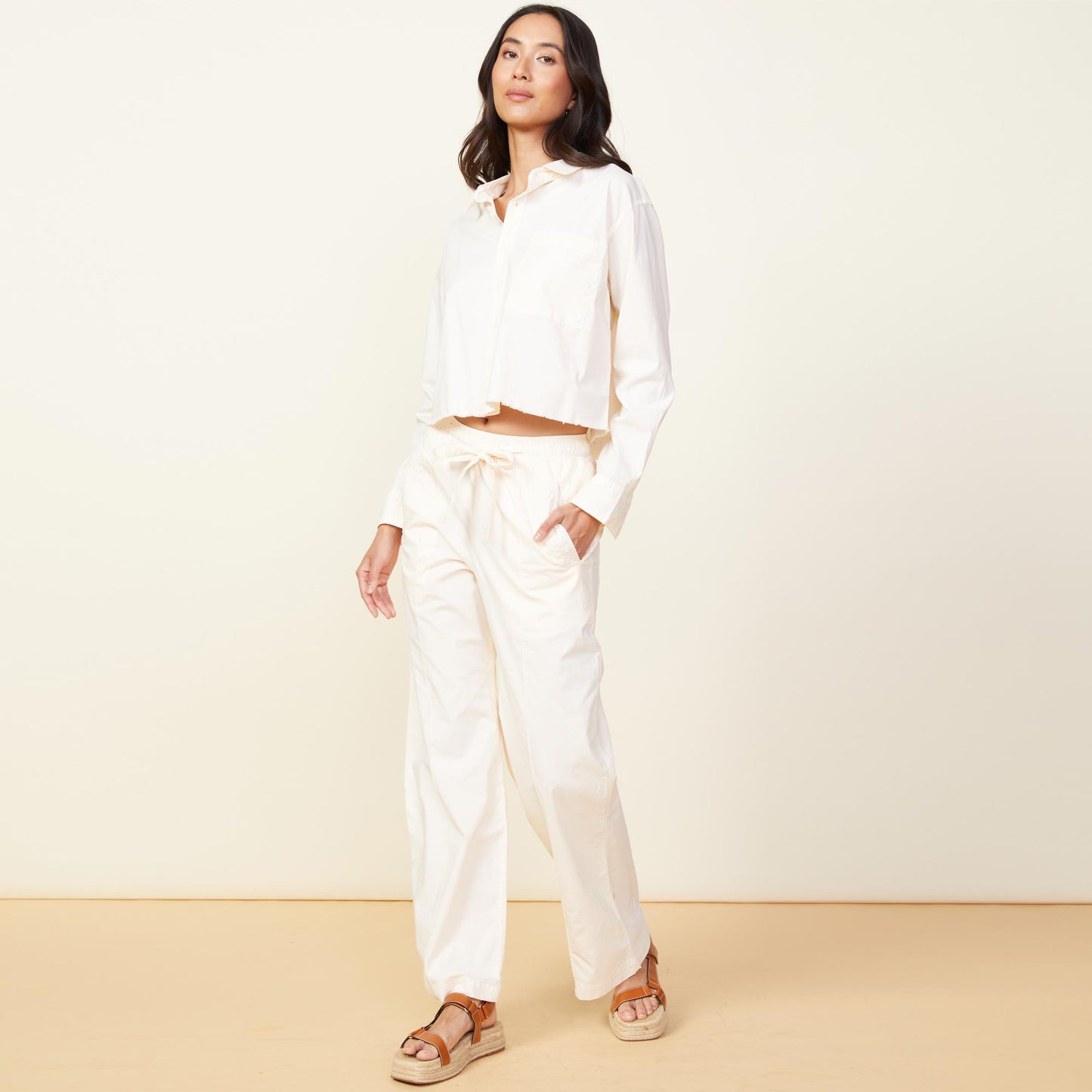 Front view of model wearing the poplin pocket pants in off white.