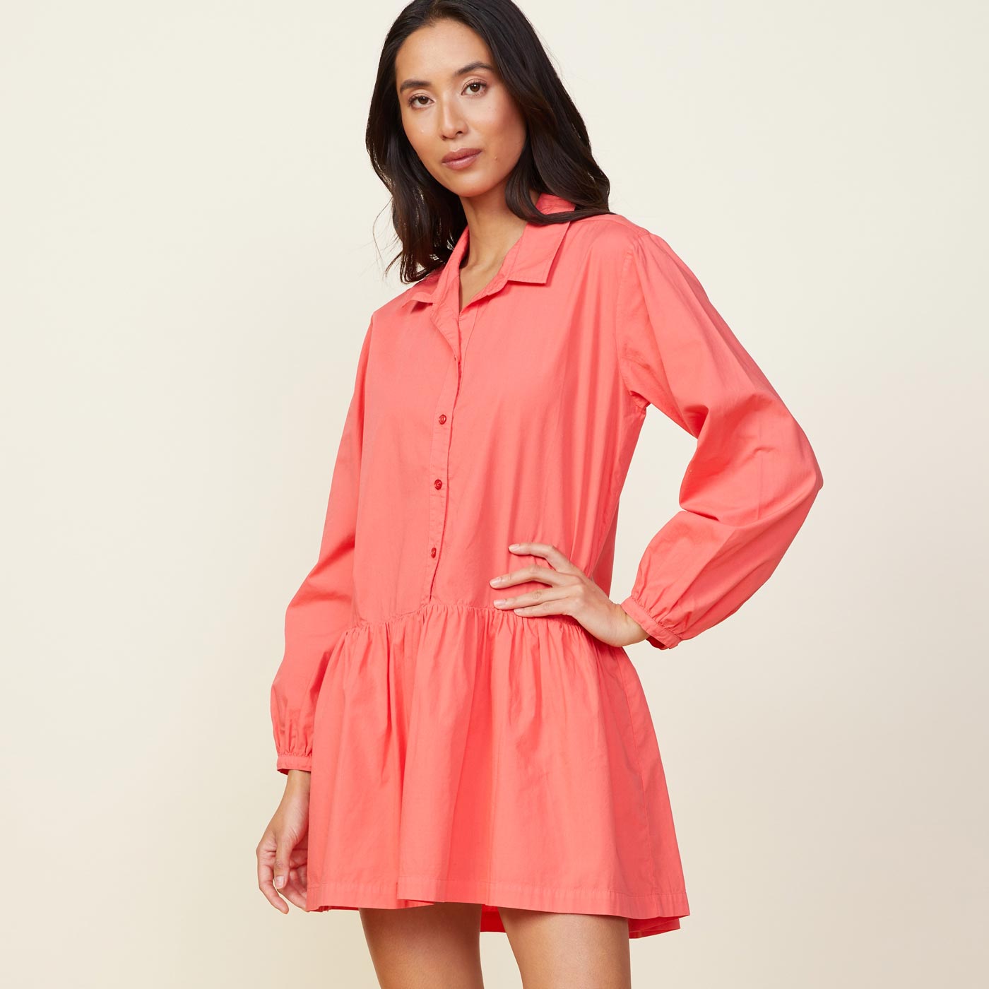 Side view of model wearing the poplin easy shirt dress in watermelon.