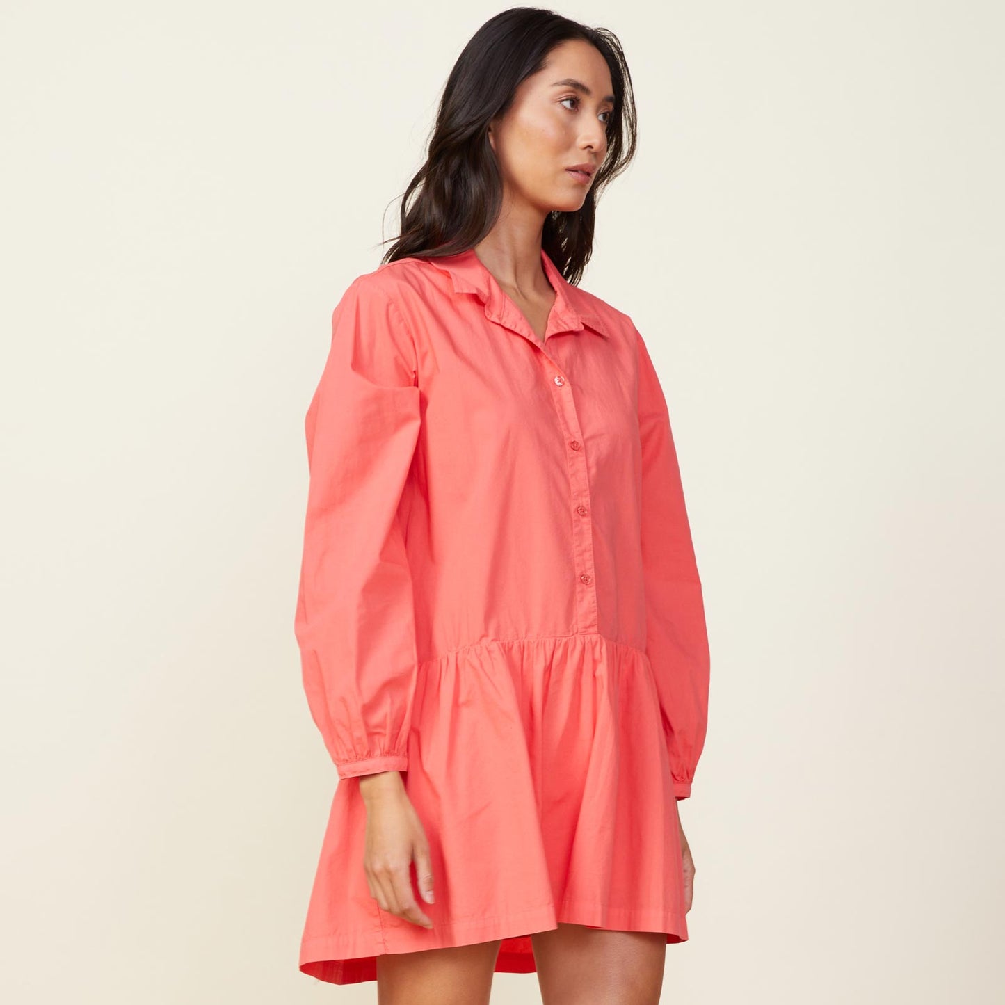 Side view of model wearing the poplin easy shirt dress in watermelon.