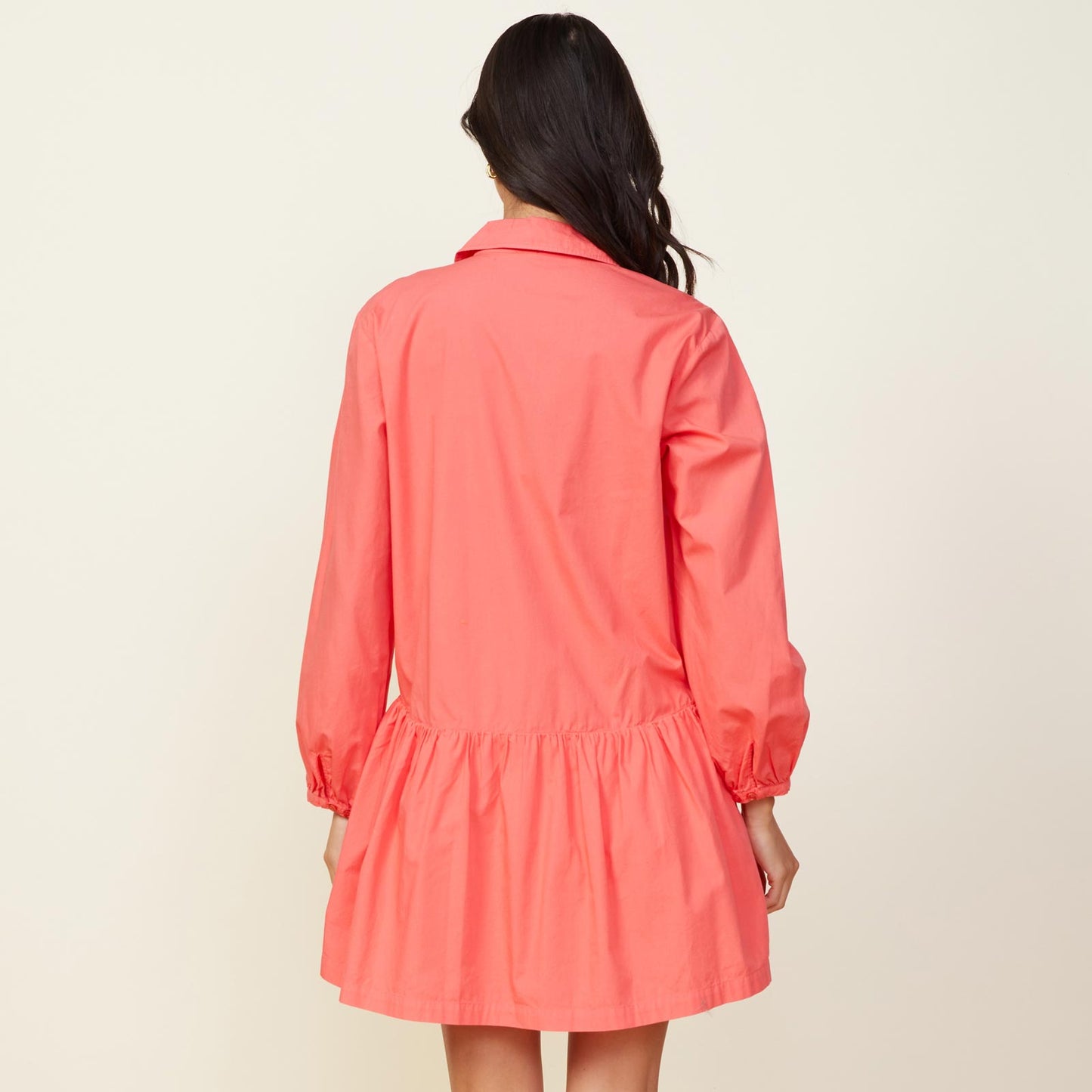 Back view of model wearing the poplin easy shirt dress in watermelon.