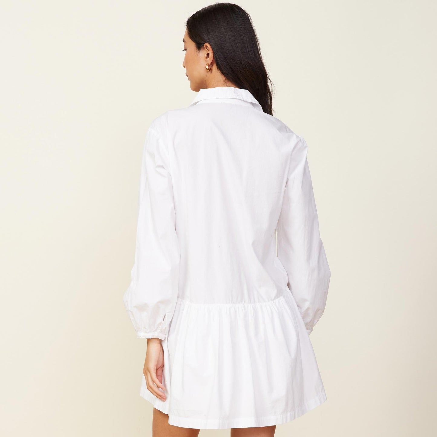 Back view of model wearing the poplin easy shirt dress in white.