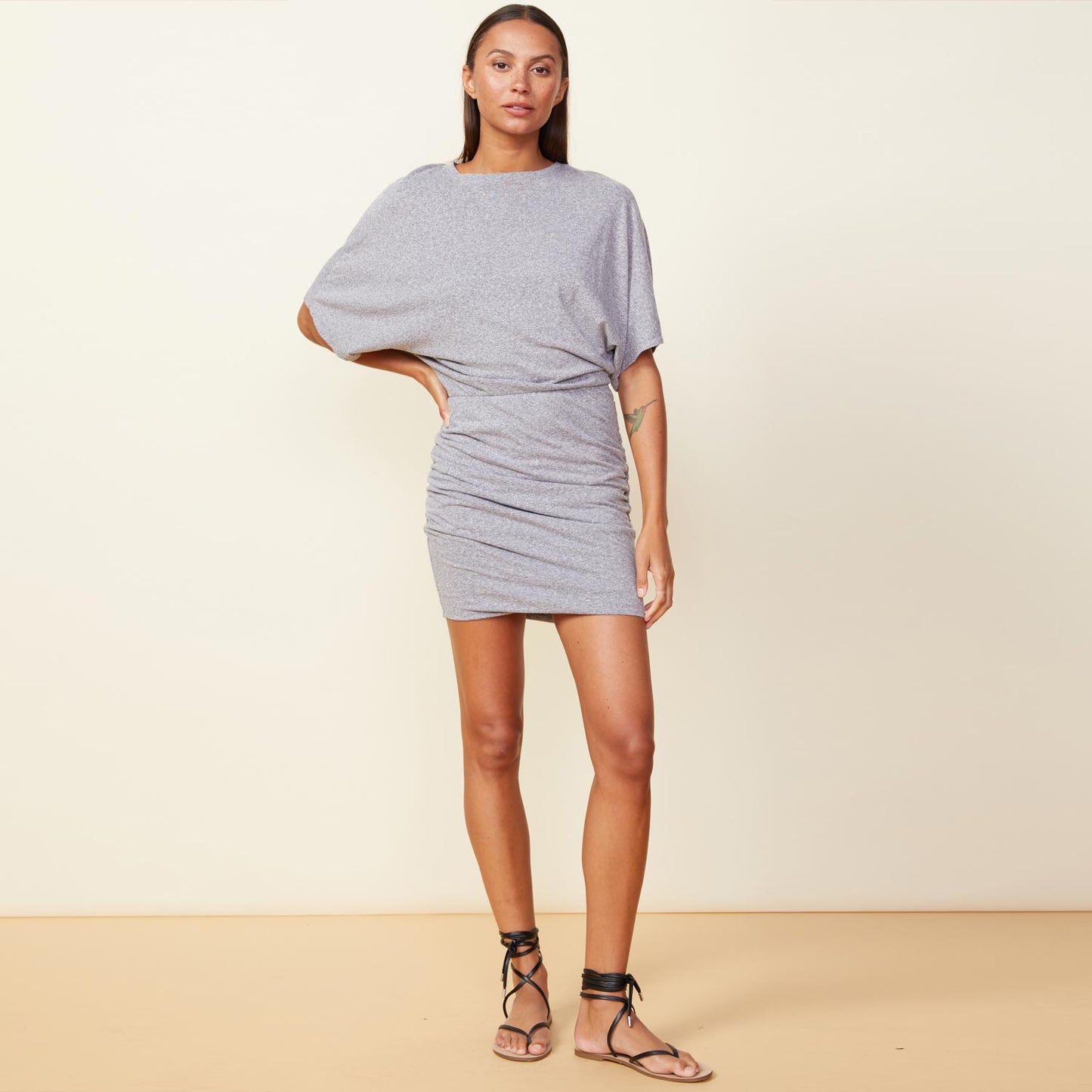 Front view of model wearing the shirred mini dress in granite.
