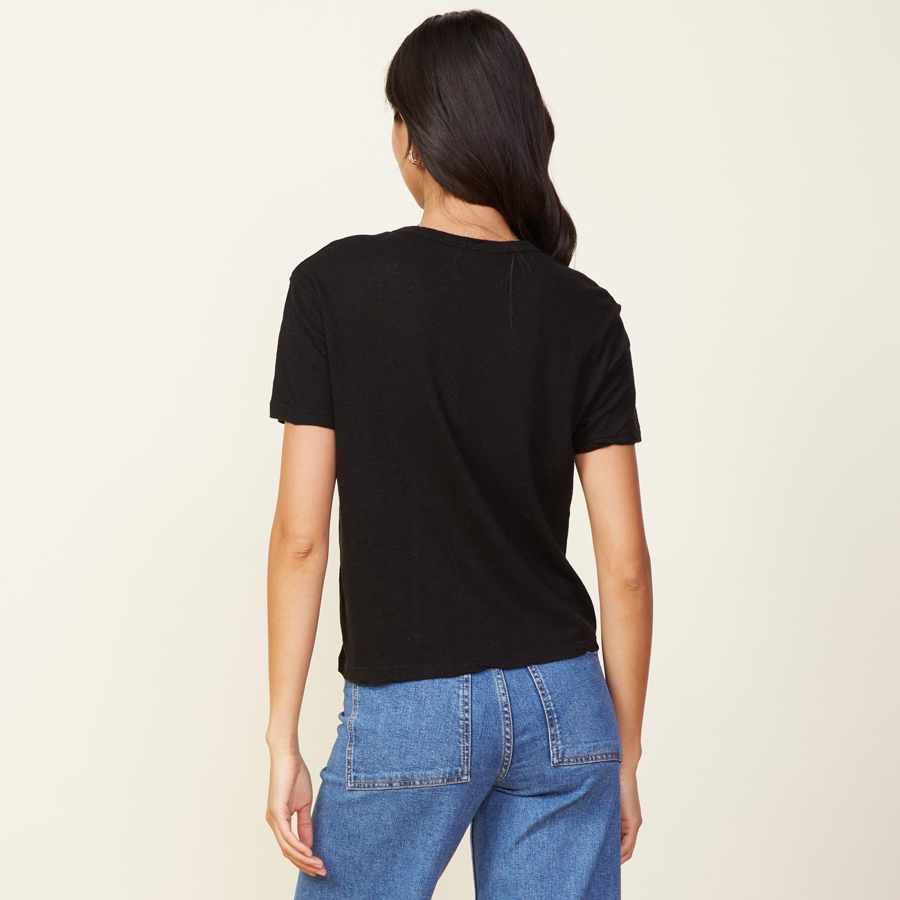 Back view of model wearing the linen athletic tee in black.
