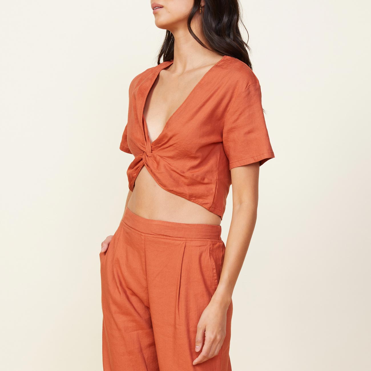 Side view of model wearing the linen front twist top in faded rust.