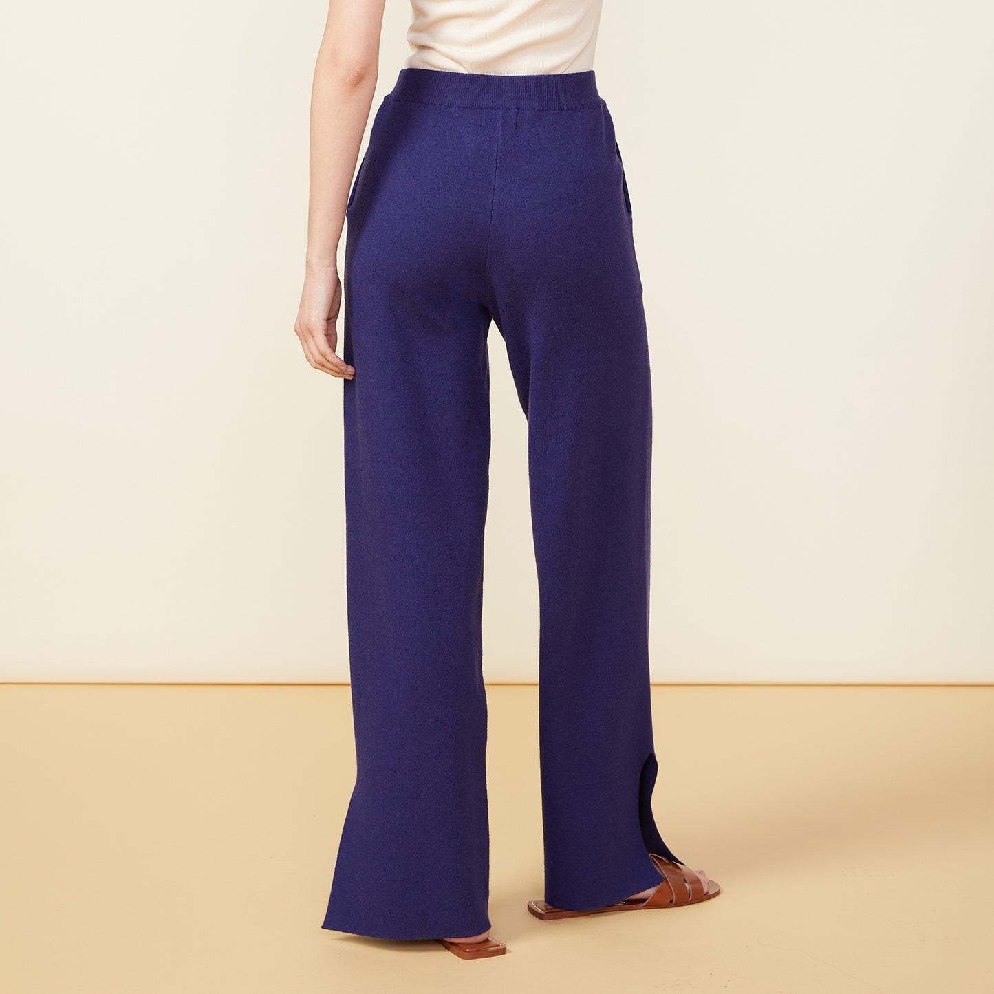 Back view of model wearing the supersoft sweater knit slit pants in navy.