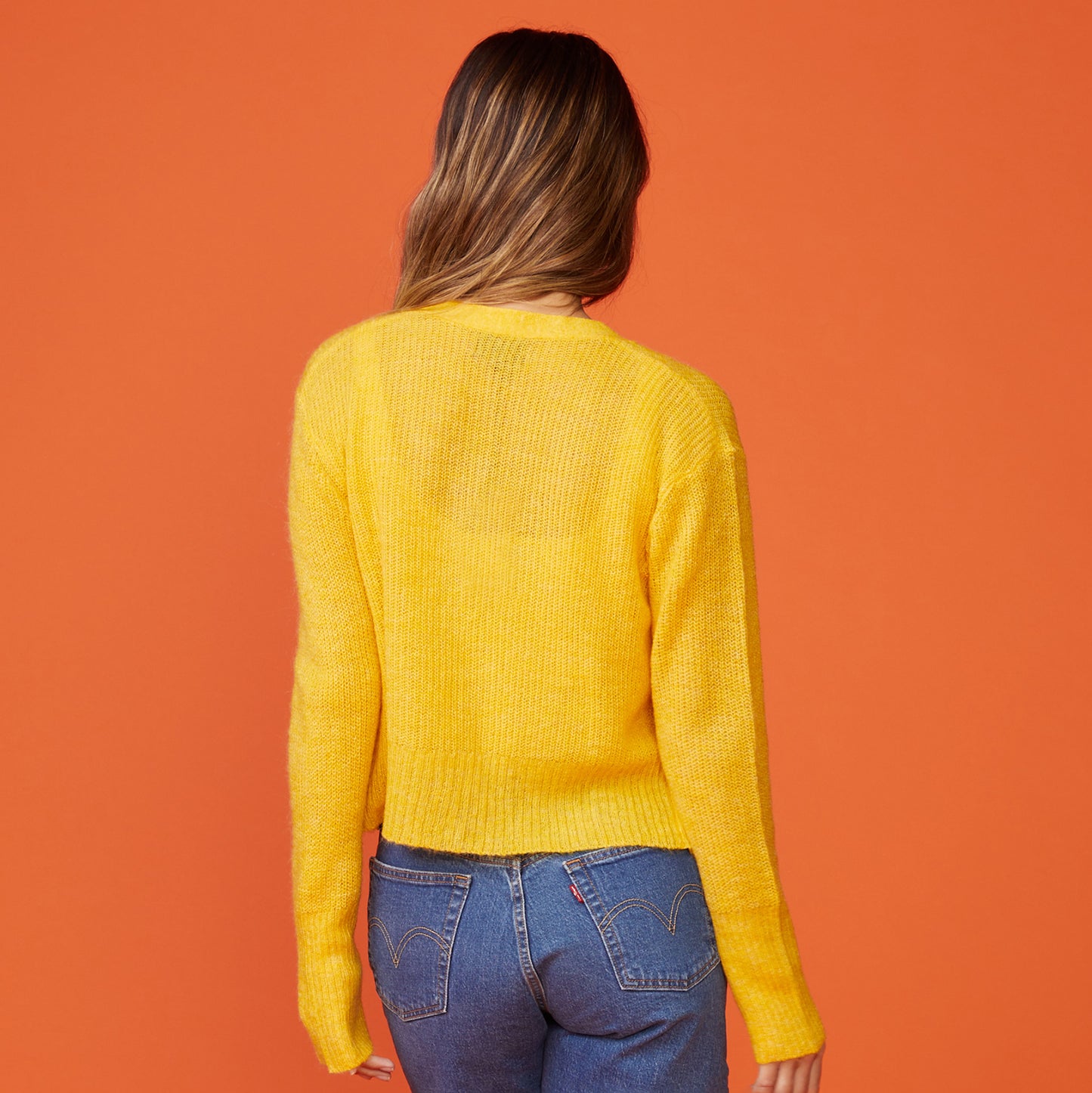 Back view of model wearing the mohair cardigan in sunshine.