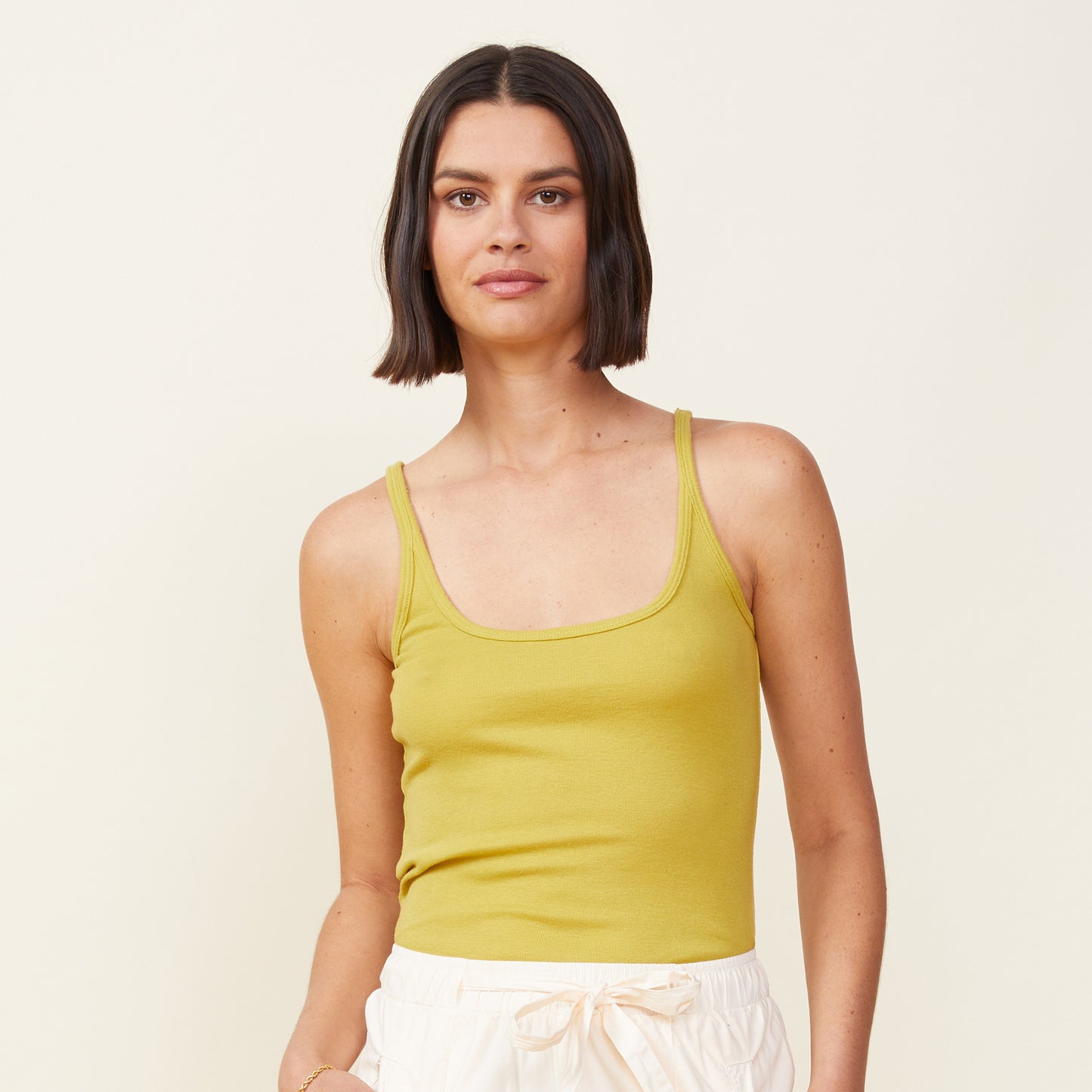 Front view of model wearing the rib strappy tank in avocado.