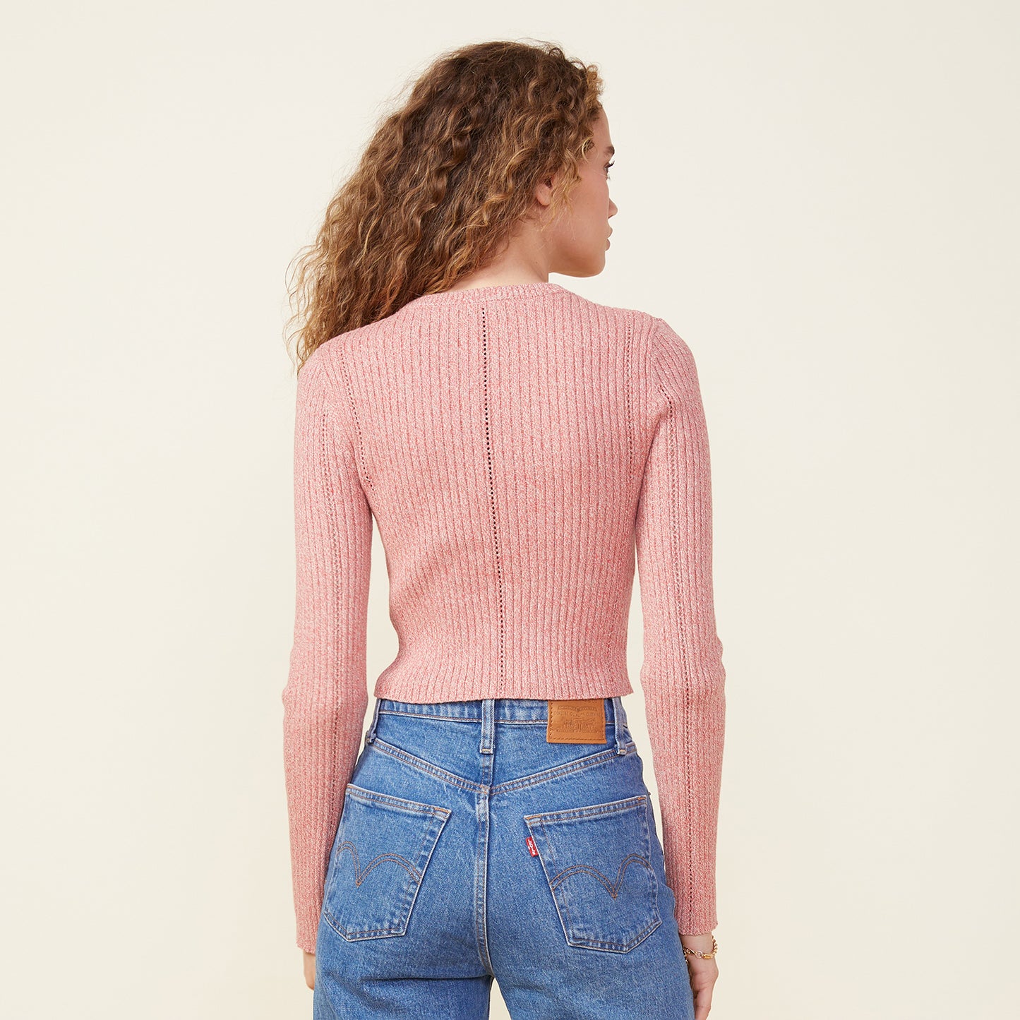 Back view of model wearing the marled sweater long sleeve top in nest.