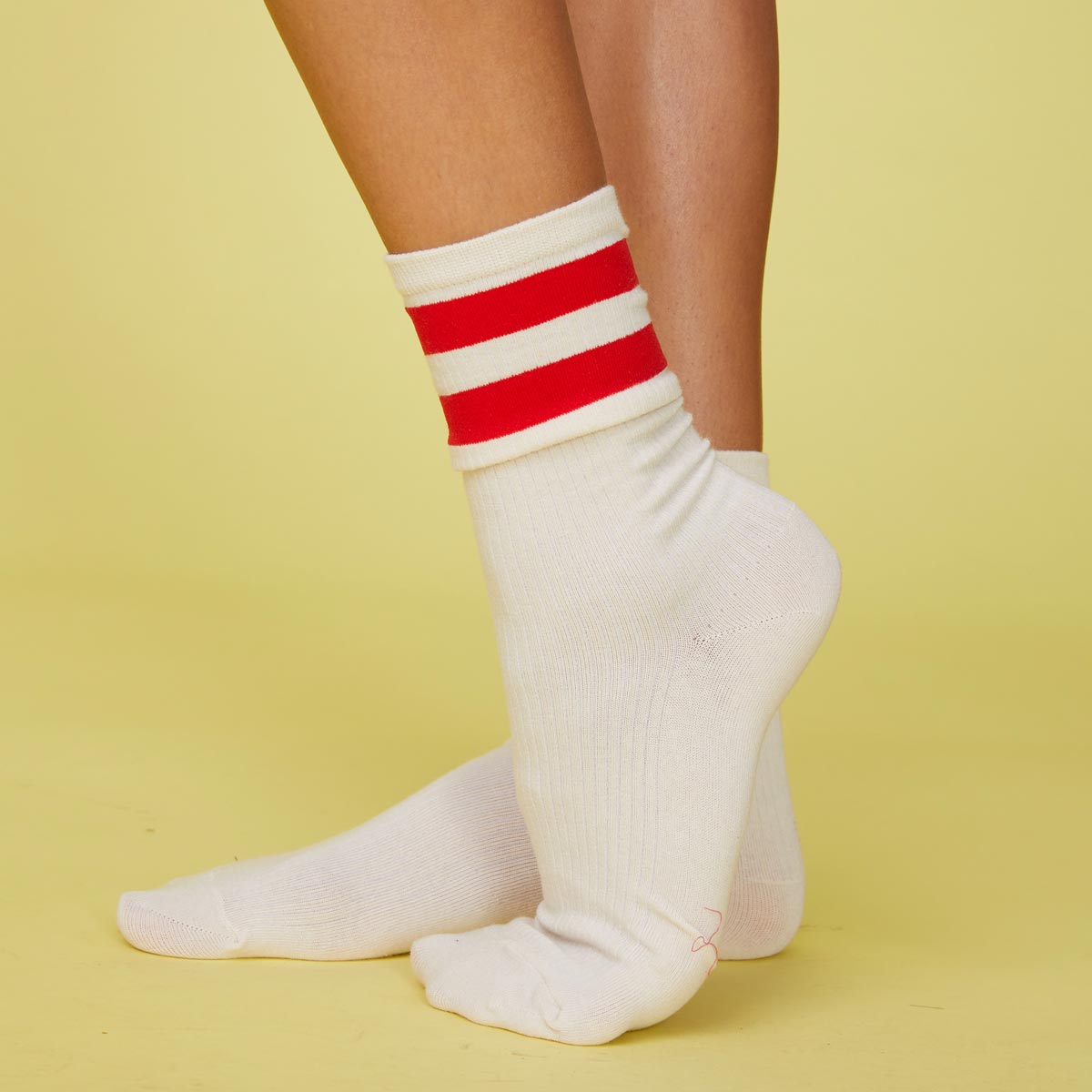 Side view of models feet wearing the stripe socks in blood red.