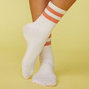 Front view of models feet wearing the stripe socks in faded rust.