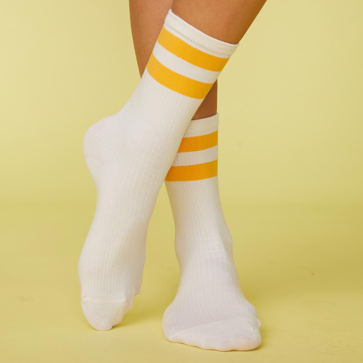 Front view of model's feet wearing the stripe socks in marigold.