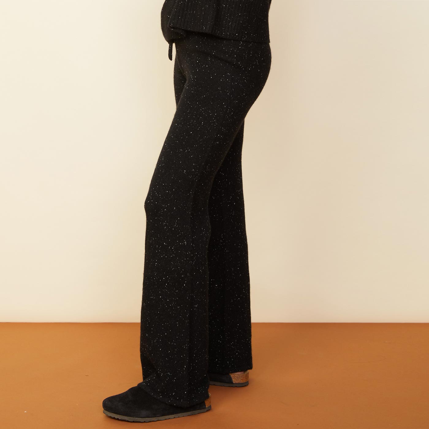 Side view of model wearing the cashmere neps lounge sweats in black.