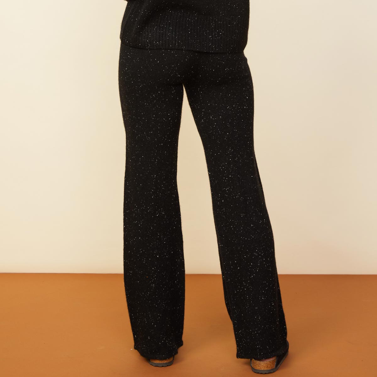 Back view of model wearing the cashmere neps lounge sweats in black.