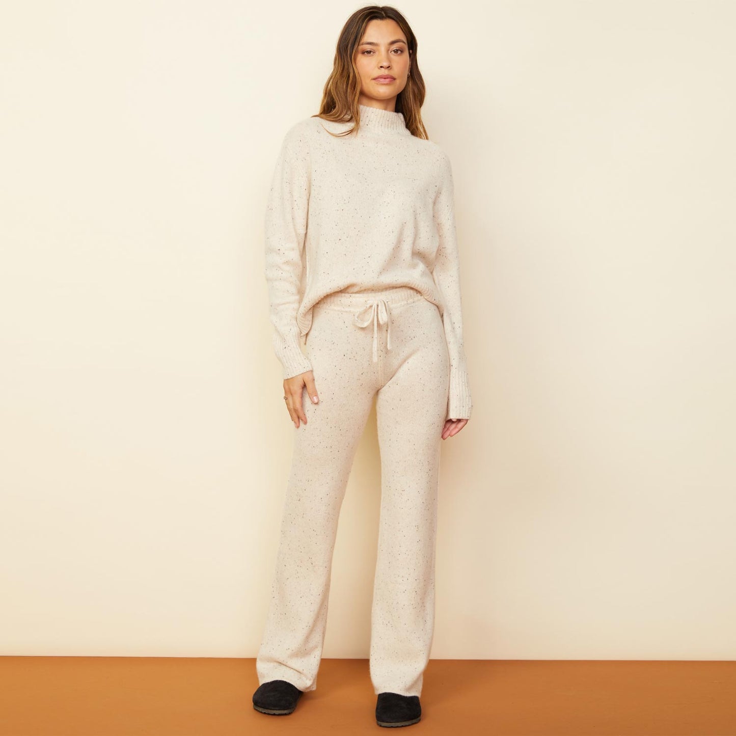 Front view of model wearing the cashmere neps lounge sweats in cream.