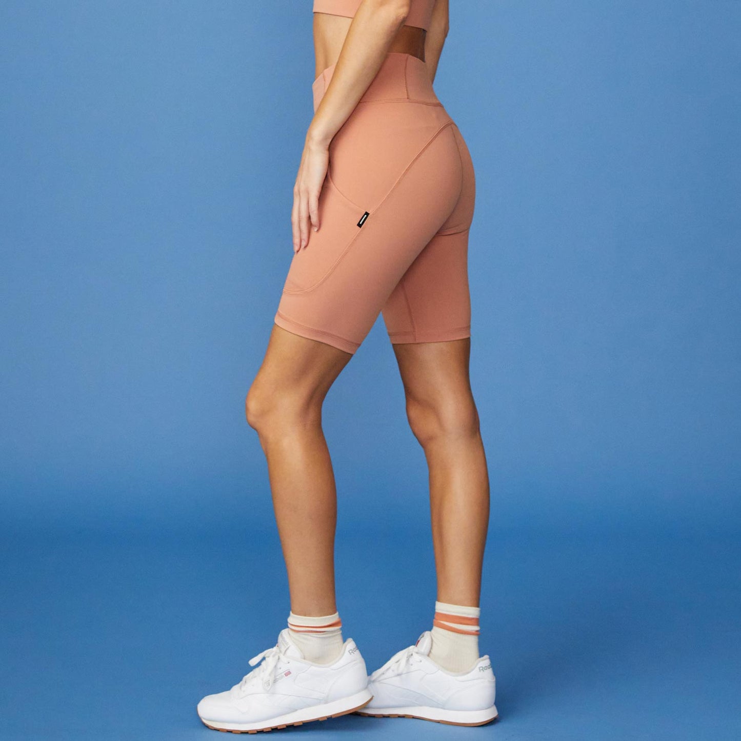 Side View of model wearing the Movement Shorts in Faded Rust