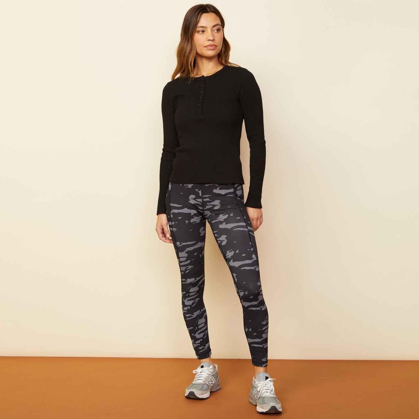 Front view of model wearing the two-tone camo movement high rise legging in vintage black.