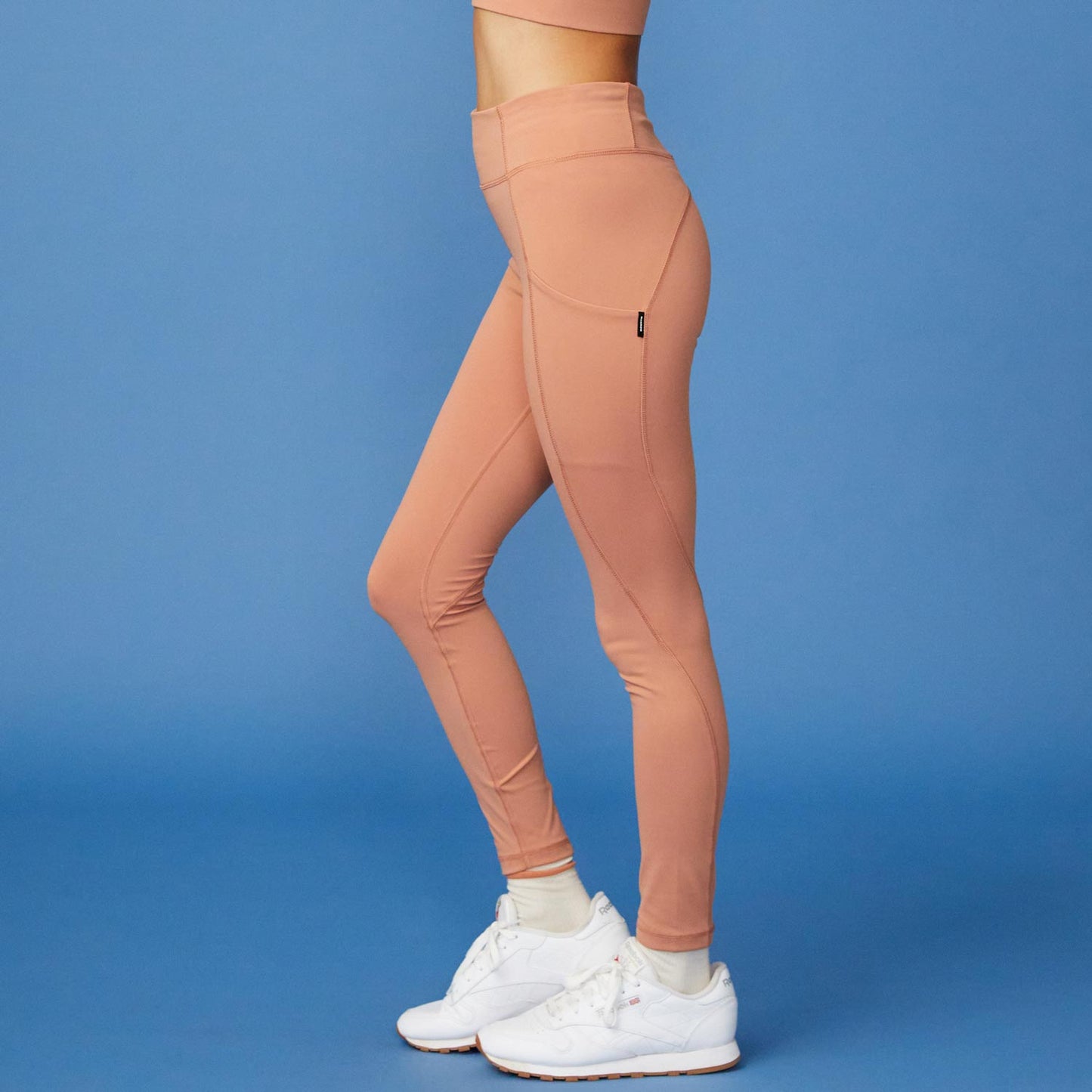 Side View of model wearing the Movement High Rise Legging in Faded Rust