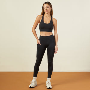 Front view of model wearing the movement high rise leggings in black.