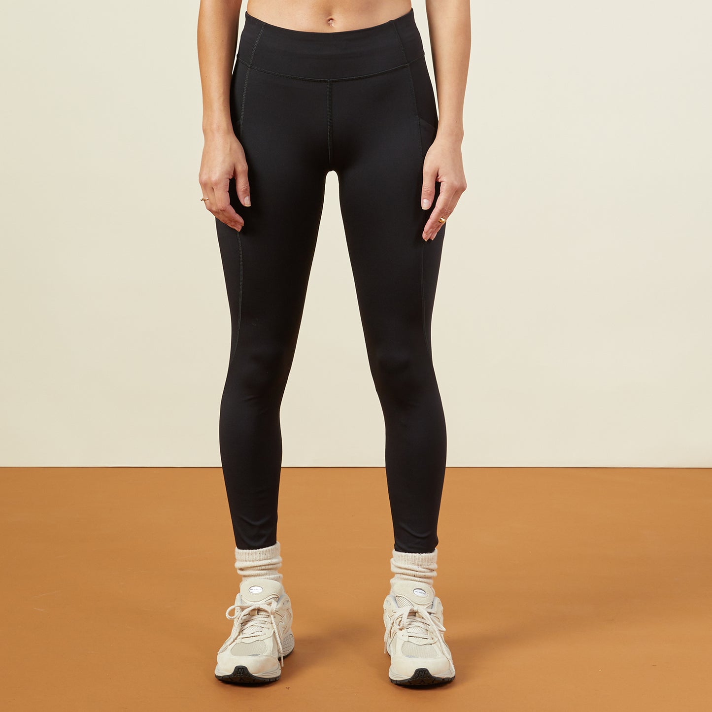 Front view of model wearing the movement high rise leggings in black.