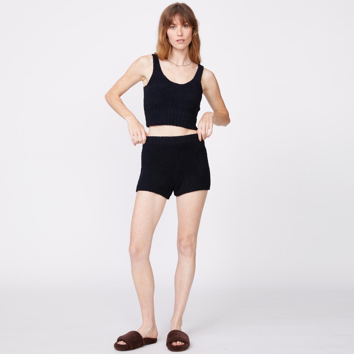 Front view of model wearing the plush sweater shorts in black.