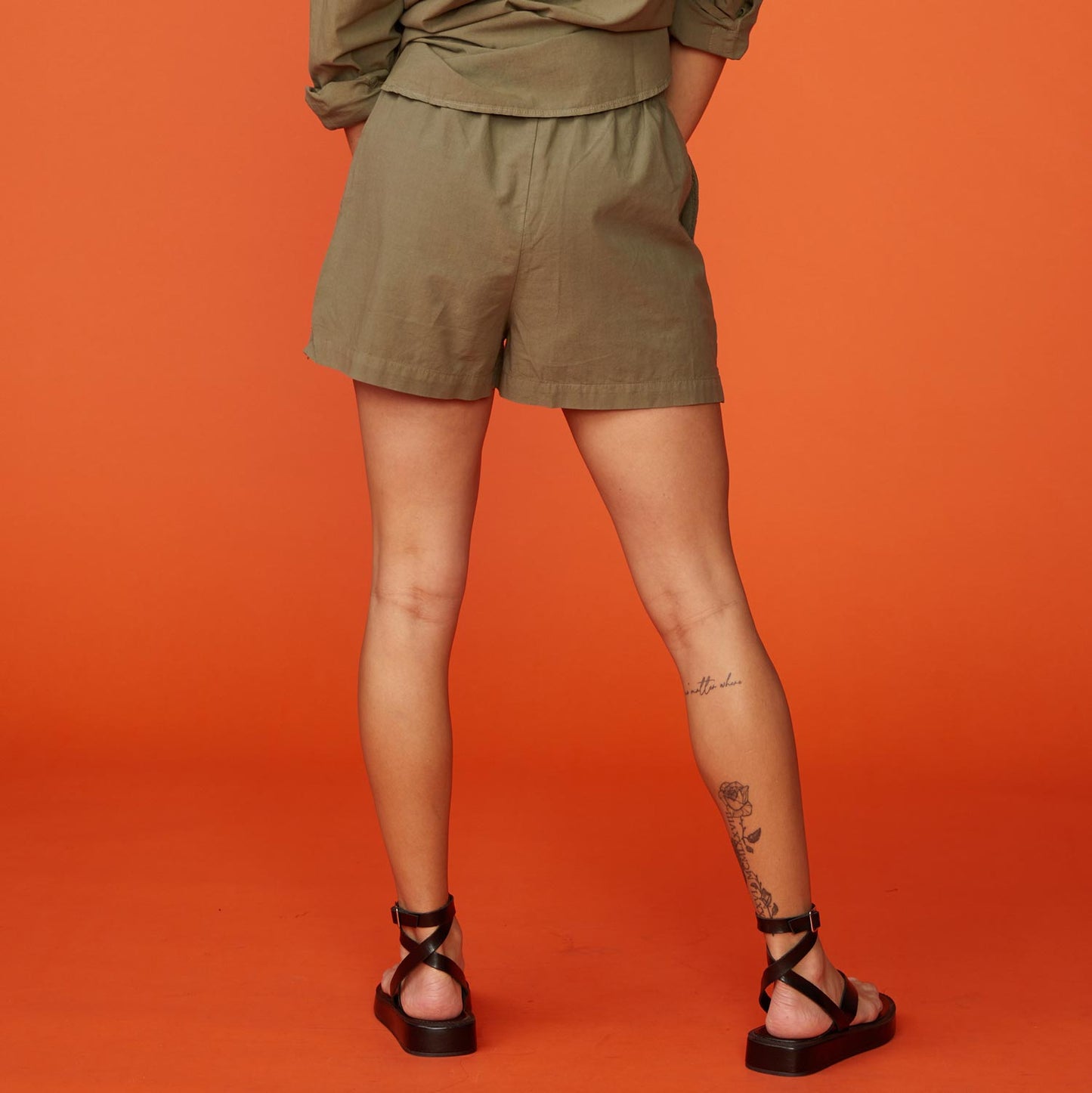 Back view of model wearing the poplin shorts in Army