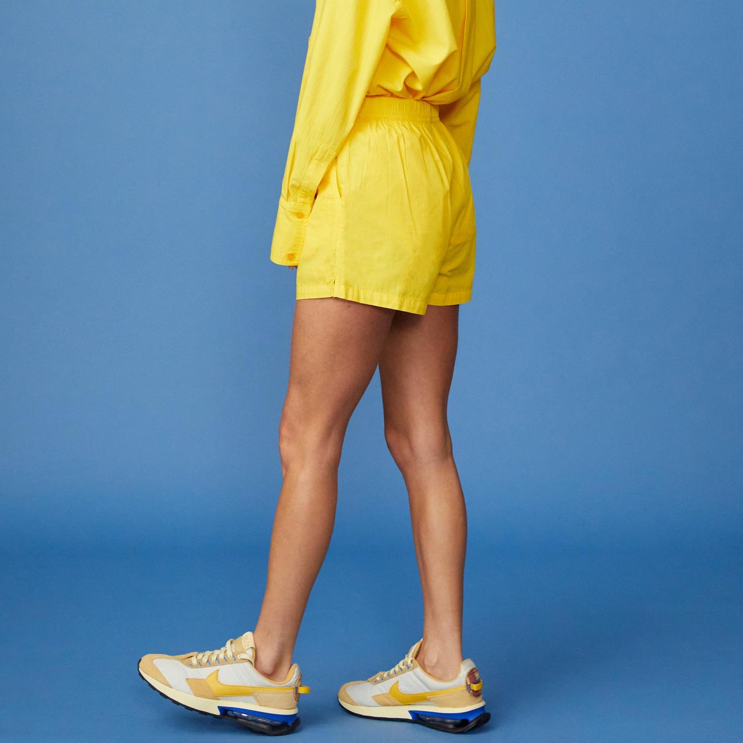 Side View of model wearing the Poplin Shorts in Sunshine