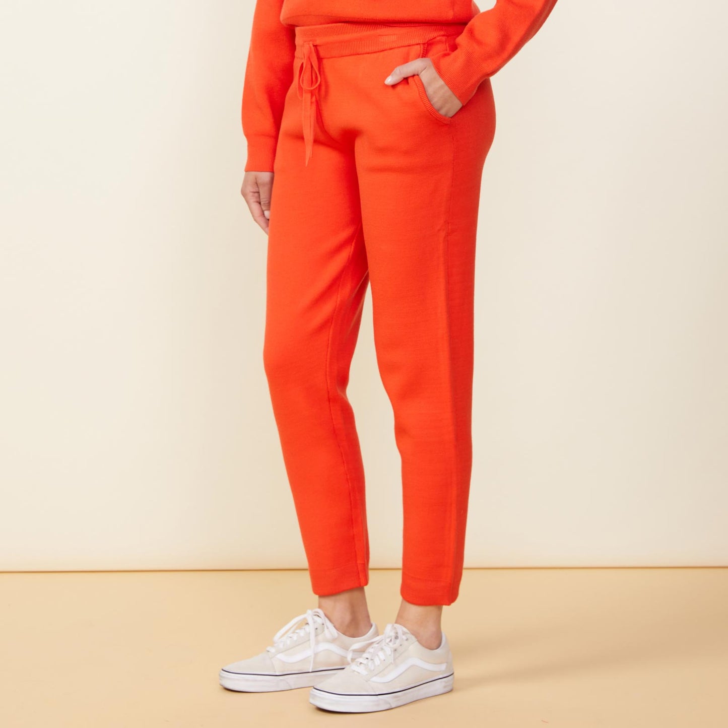 Side view of model wearing the supersoft sweater knit cuffed jogger in electric coral.