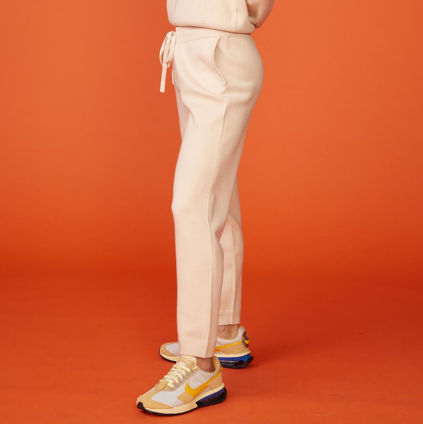 Side view of model wearing the supersoft sweater knit cuffed jogger in off white.