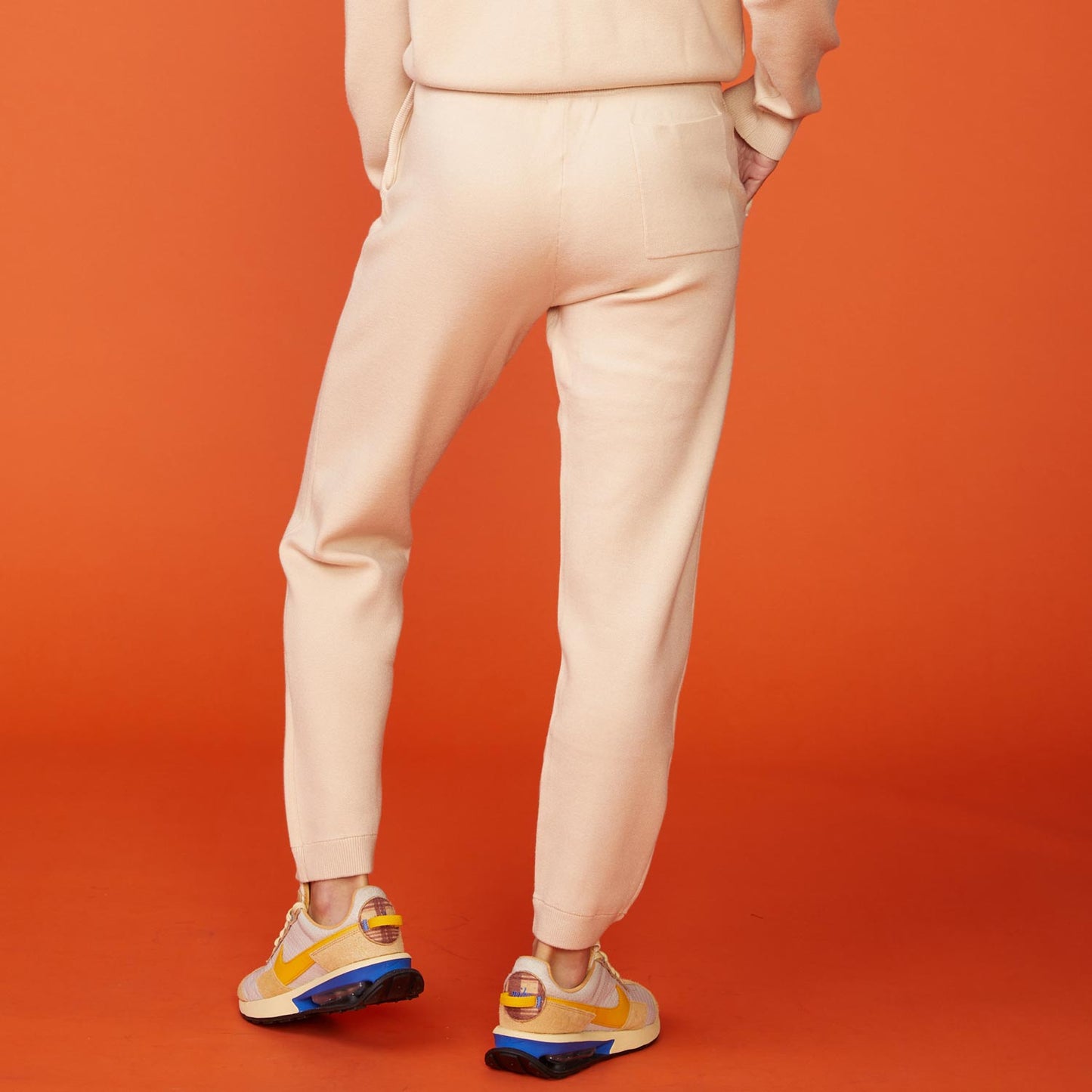 Back view of model wearing the supersoft sweater knit cuffed jogger in off white.